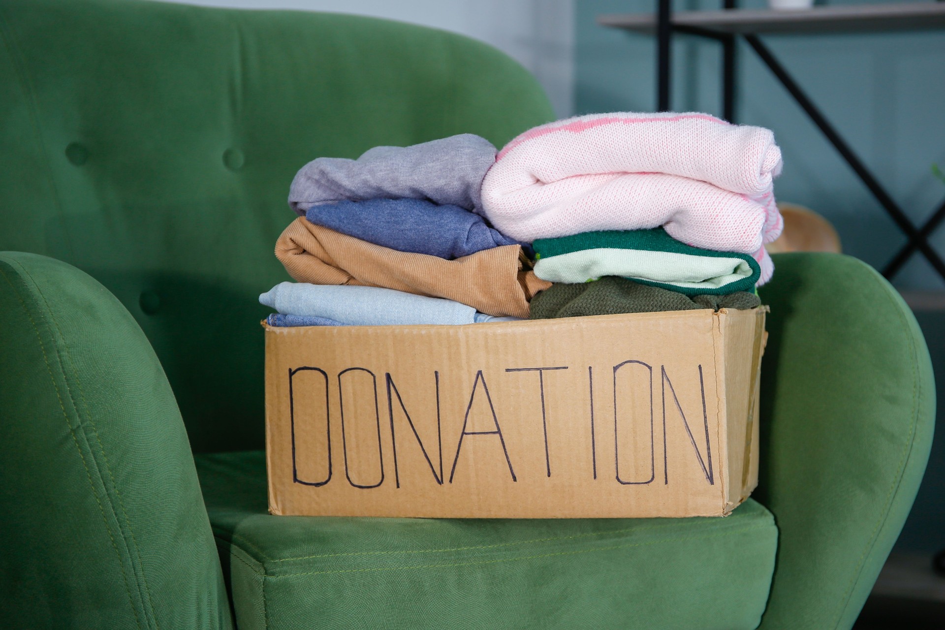 Donation box with clothes on the couch in the living room.