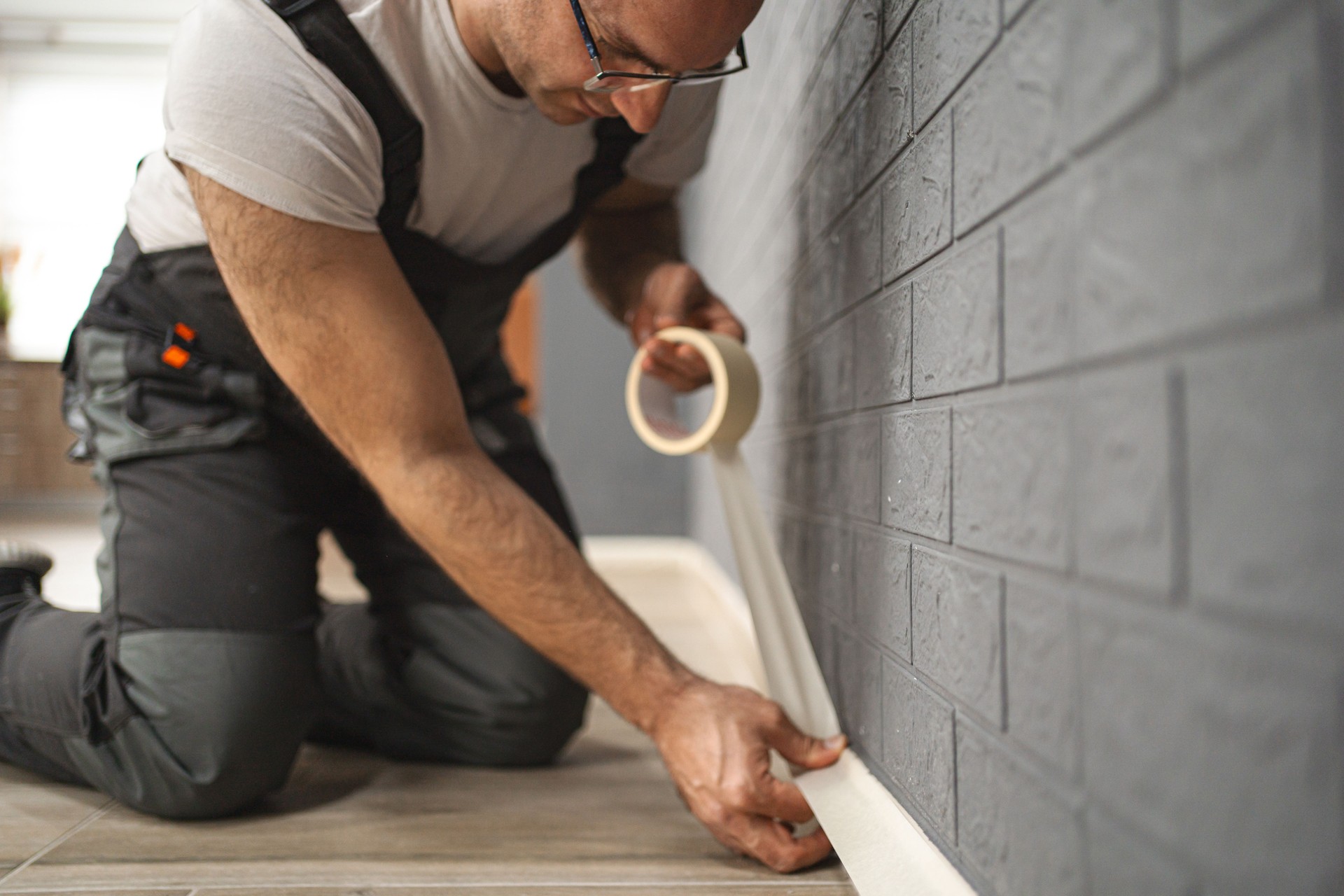 Mid adult men using masking tape before painting the wall